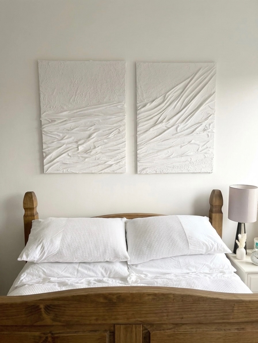 Díptico blanco sobre una cama